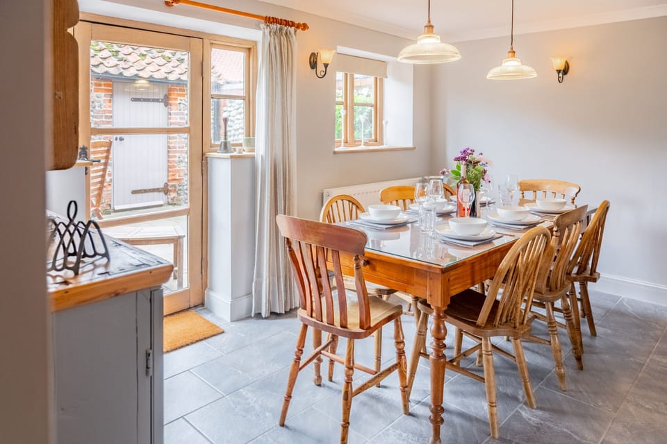 Ground floor: Dining room with seating for eight guests and door to the garden