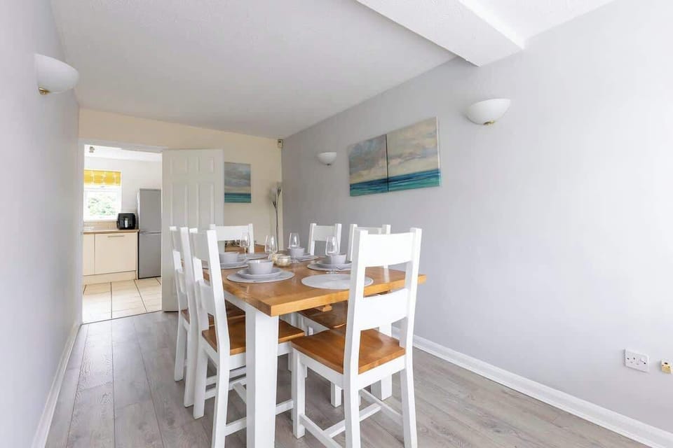 “A fresh, white dining area that’s both simple and spacious — ideal for family dinners or friendly get-togethers.”