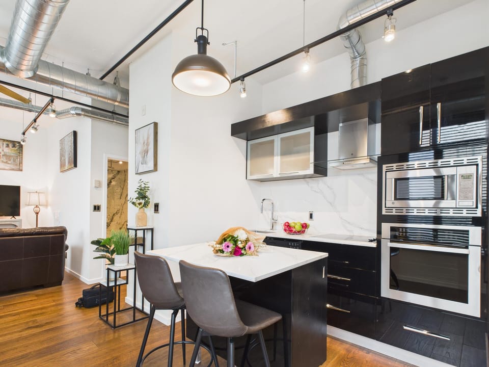 Fully equipped kitchen complete with modern appliances, integrated microwave, and island seating.