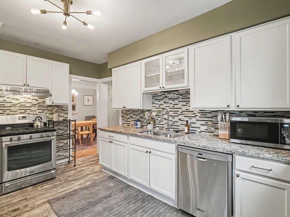 Cook with ease in this stunning kitchen! Features include sleek white cabinets, granite counters, and modern stainless appliances. The open layout leads right to a cozy dining area, perfect for sharing meals and memories.