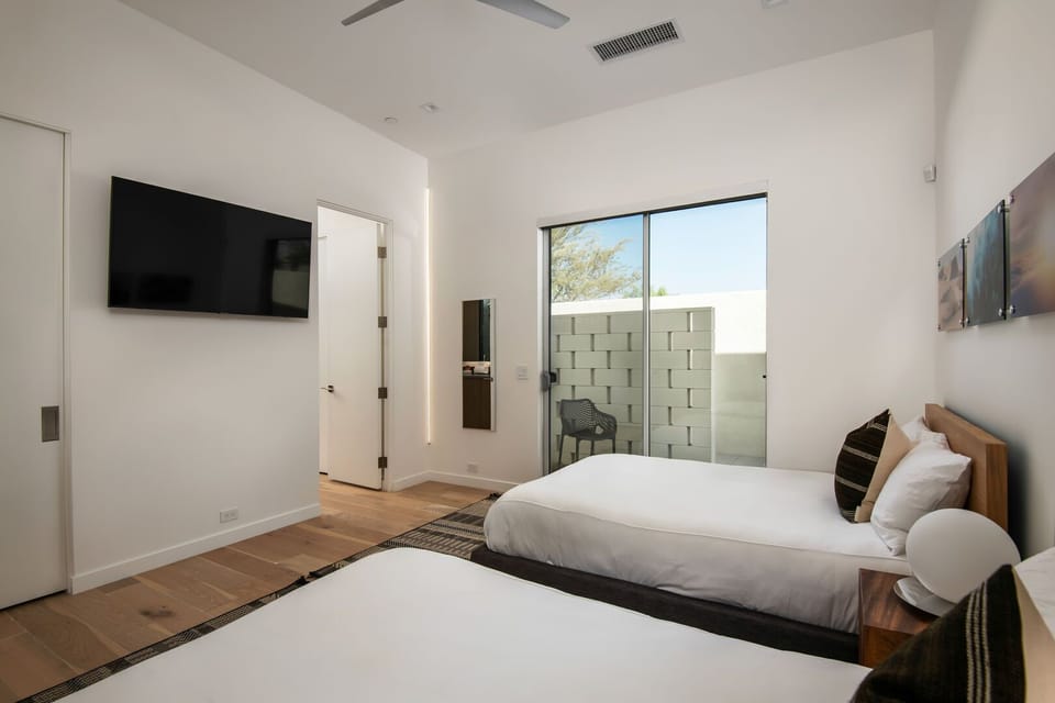 The Twin Bedroom viewed from the hallway, highlighting the ample space, closet, and modern finishes.