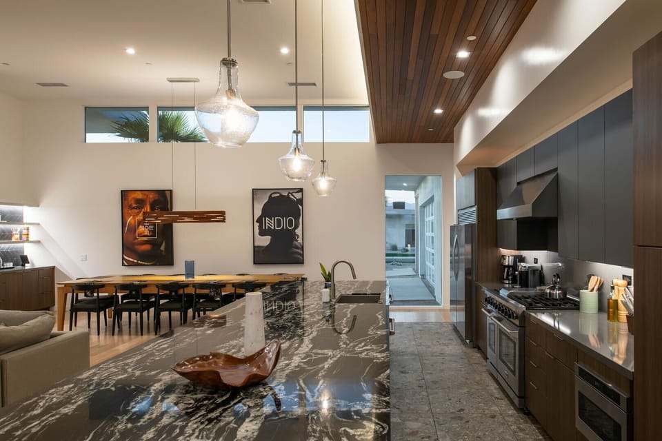 A detailed look at the gourmet chef's kitchen, featuring a massive marble island with bar seating, a professional range, and a sleek, built-in wine cooler.