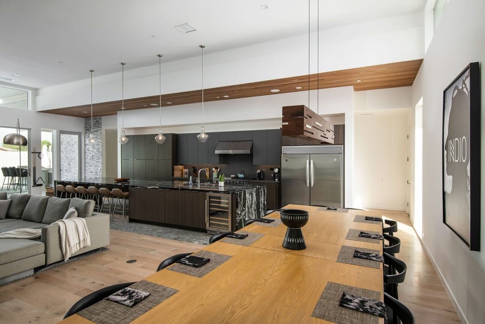 The expansive chef's kitchen and dining area, featuring a massive marble island, professional appliances, and plenty of seating for your entire group.