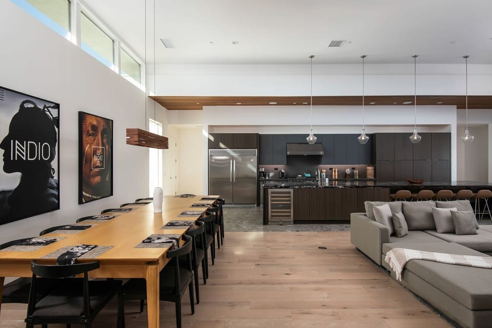 The spectacular open floor plan, showing the seamless connection between the oversized dining table, living room, and gourmet kitchen.