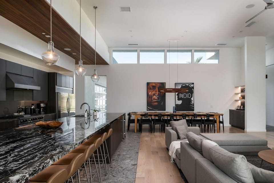 The stunning open-concept interior, showing the continuous flow between the modern kitchen island, living room, and dining space.
