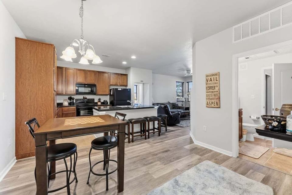 Your modern kitchen flows seamlessly into the dining area, where you'll gather around the breakfast bar for morning coffee or evening conversations.