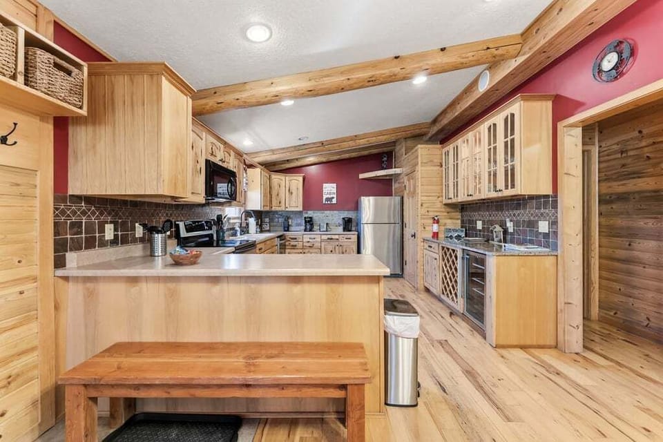 Your dream cabin kitchen awaits at 279 Shorewood Drive with warm wood tones, granite counters, and rustic beams overhead—perfect for cooking hearty mountain meals.