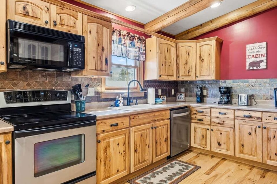 Your fully equipped cabin kitchen at 279 Shorewood Drive features rustic wood cabinets, modern appliances, and everything needed to cook memorable meals.