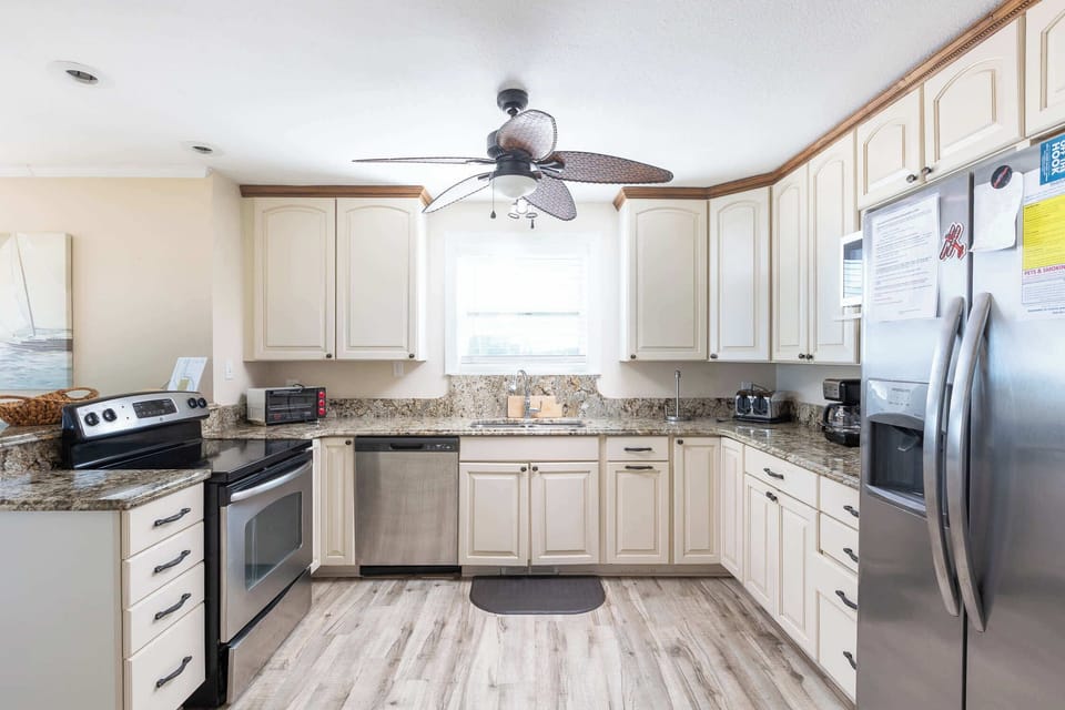 Mid Level: Fully equipped Kitchen featuring breakfast bar seating for 2, stove, dishwasher, refrigerator, oven, microwave, toaster, drip coffee, blender, hand mixer and much more