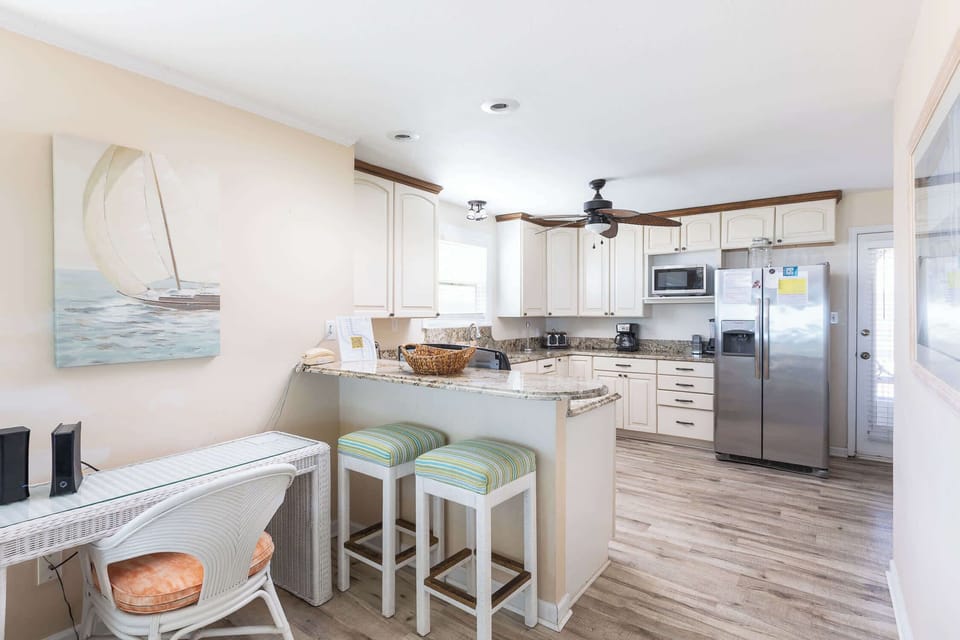 Mid Level: Fully equipped Kitchen featuring breakfast bar seating for 2, stove, dishwasher, refrigerator, oven, microwave, toaster, drip coffee, blender, hand mixer and much more