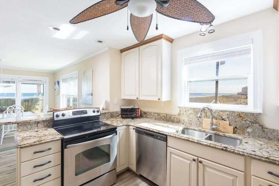 Mid Level: Fully equipped Kitchen featuring breakfast bar seating for 2, stove, dishwasher, refrigerator, oven, microwave, toaster, drip coffee, blender, hand mixer and much more
