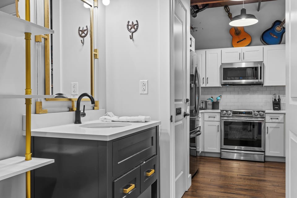 Stylish bathroom with gold accents, large mirror, and ample counter space.