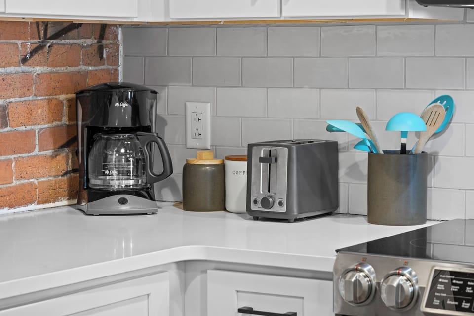 Coffee station with coffee maker, toaster, and kitchen essentials.