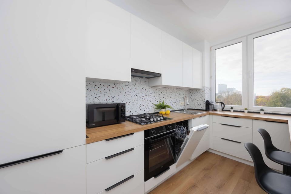 Modern kitchen with appliances – Equipped with dishwasher, oven, and coffee maker.