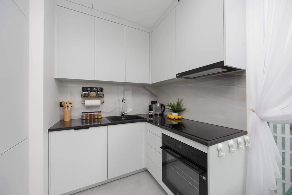 Minimalist white kitchen – Fully equipped kitchen with modern appliances for all your cooking needs.