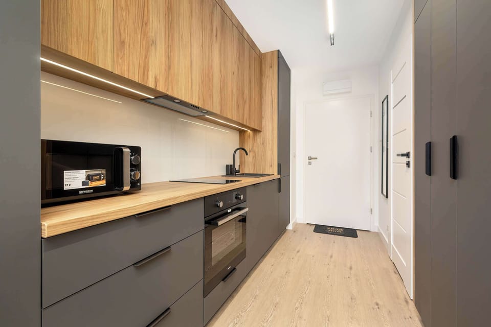 Fully equipped kitchen – Complete with modern oven, sink, and stylish wood cabinetry.
