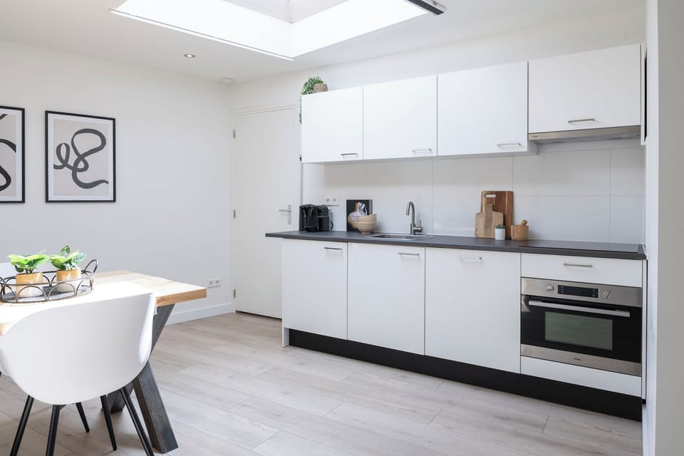 Modern kitchenette with all essentials, sleek storage, and bright natural light — ideal for cooking simple meals.