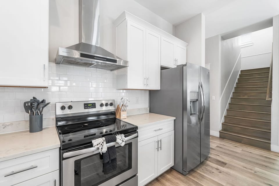 Premium stainless steel appliances elevate this bright kitchen with a clean, modern coastal aesthetic.
