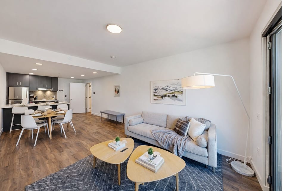Relax in your stylish living space where modern comfort meets sleek design, featuring cozy seating and an open kitchen perfect for memorable meals.