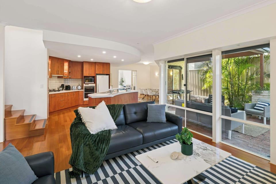 Contemporary living area with large windows and quality flooring.