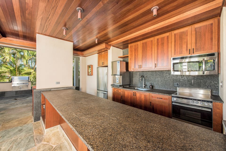 Guests enjoy private access to the poolside pavilion with gas grills, outdoor kitchen, and lounge.