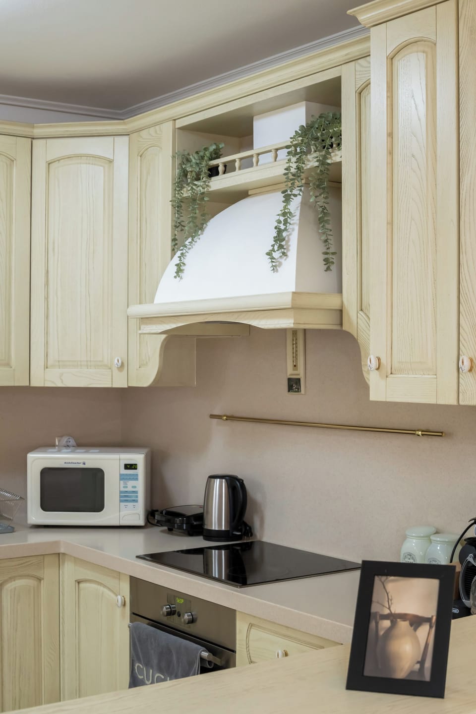 Modern kitchen with elegant cream cabinetry and sleek appliances.