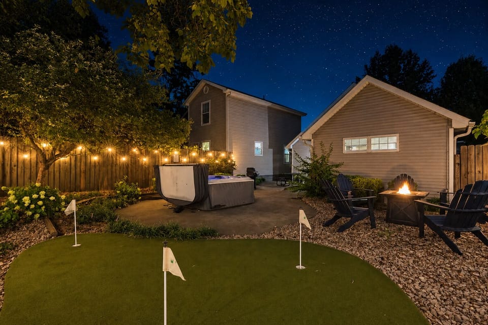 Private backyard oasis with hot tub, fire pit, and putting green