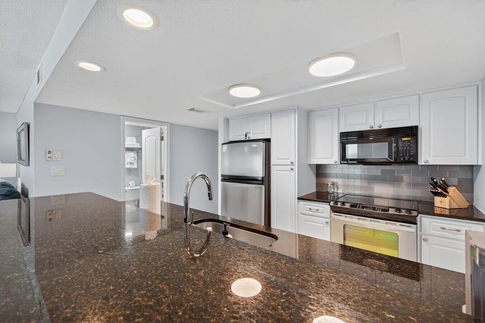 Bright kitchen w/ granite counters, ample prep space & seating for casual meals.