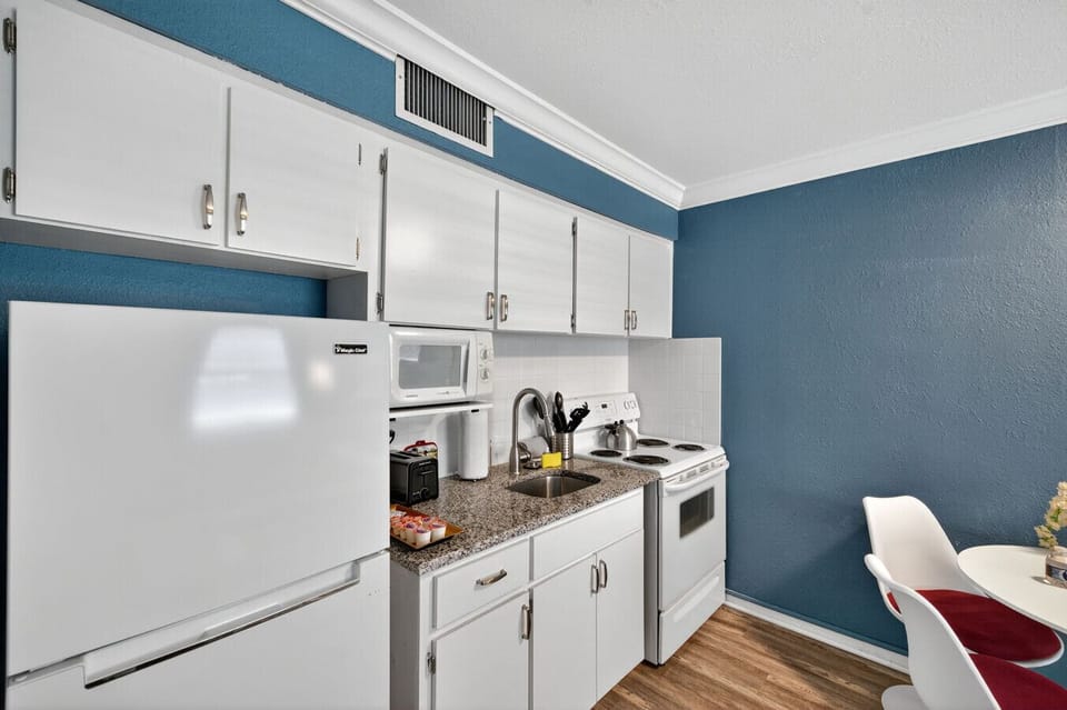 Clean, modern kitchen w/ white cabinetry & everything you need for easy home-cooked meals.