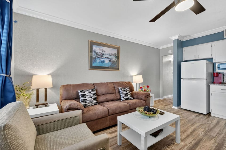 Comfortable lounge setup w/ plush sofa, side tables, and natural light.