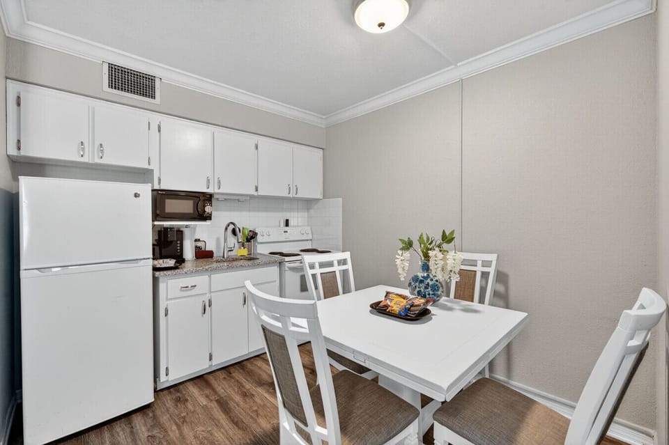 Clean, open kitchen w/ dining table, perfect for casual meals & conversation.