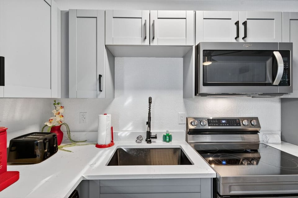 Modern kitchen w/ stainless appliances, clean counters, and a bright, streamlined look.