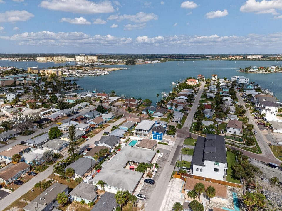 Wide aerial perspective highlighting rooftops, waterways, and open coastal surroundings.