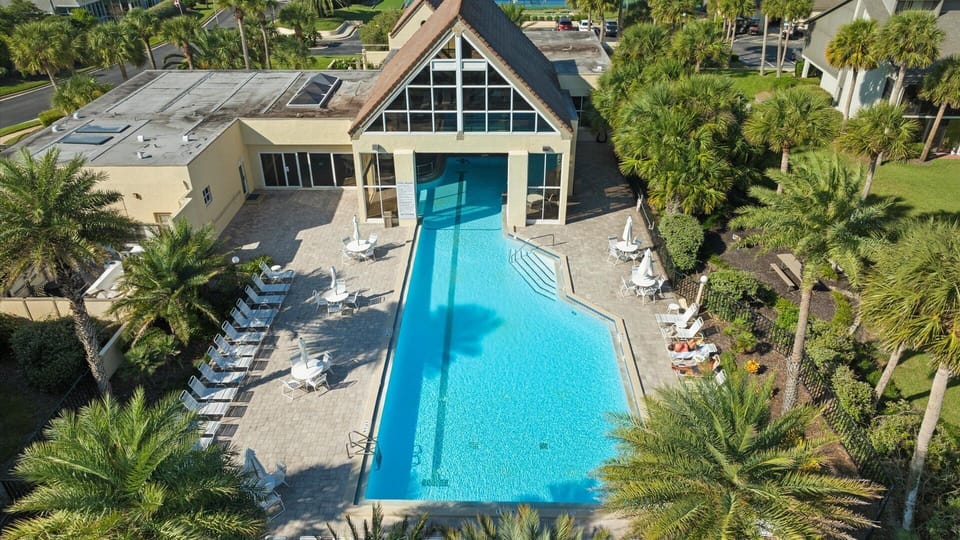 Relax at the heated community resort-style pool, surrounded by palm trees and comfortable lounge seating - perfect for enjoying a refreshing swim year-round.