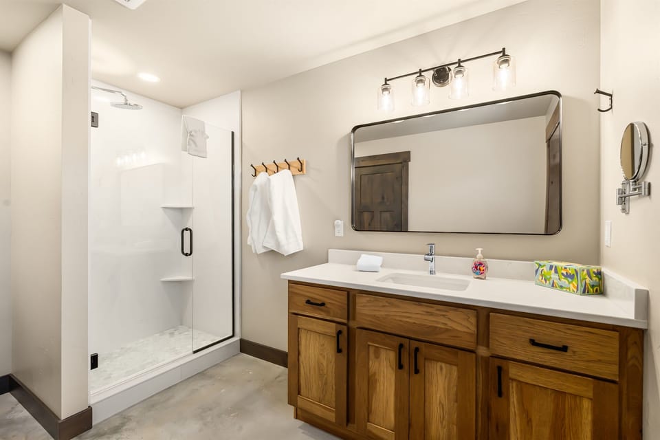 Bathroom 1, Bright bathroom with glass walk-in rain shower, wood vanity, quartz countertop and hook rail with fresh towels. Shampoo, conditioner, Body wash & Lotion provided, Makeup mirror