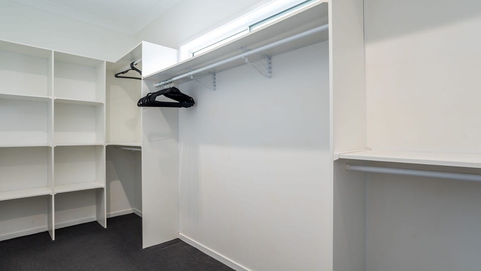 Spacious walk-in closet with built-in shelving.