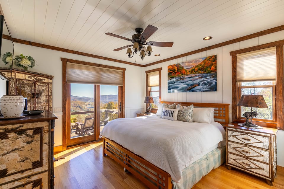Wake up to sweeping Blue Ridge views right from your pillow. Rustic charm meets comfort in this king bedroom at Over The Top Lodge At Chappell Farms.