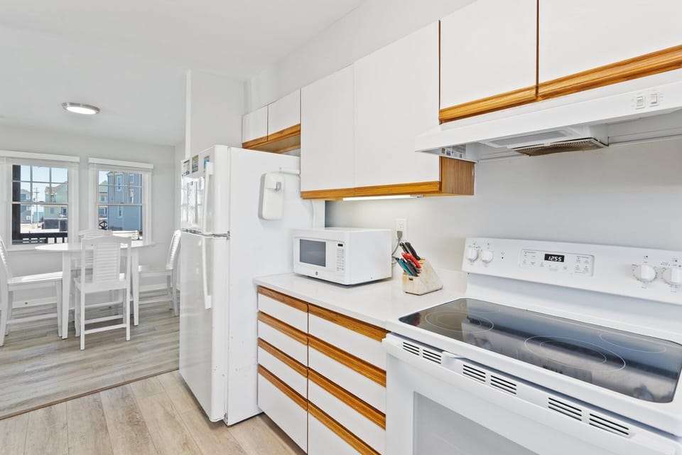 Prepare fresh meals or quick snacks in the updated kitchen featuring modern appliances and stone countertops.