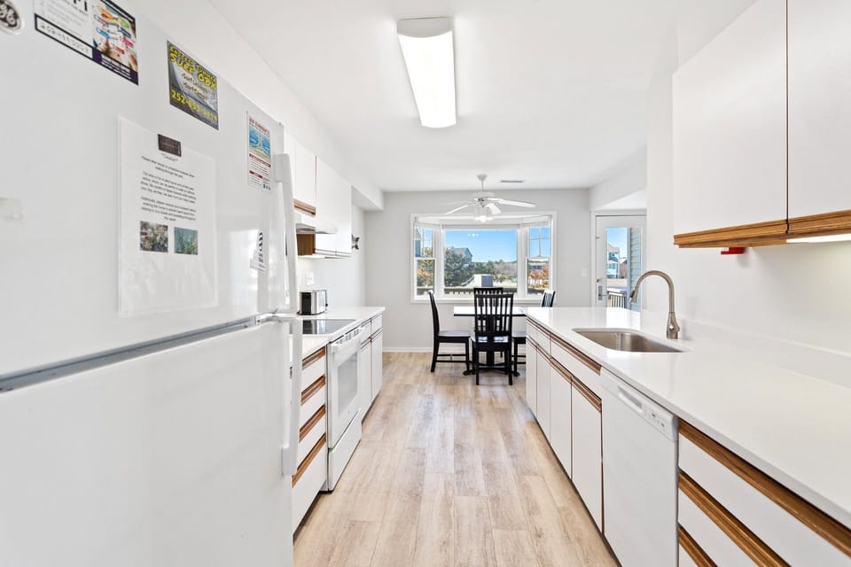 Prepare fresh meals or quick snacks in the updated kitchen featuring modern appliances and stone countertops.