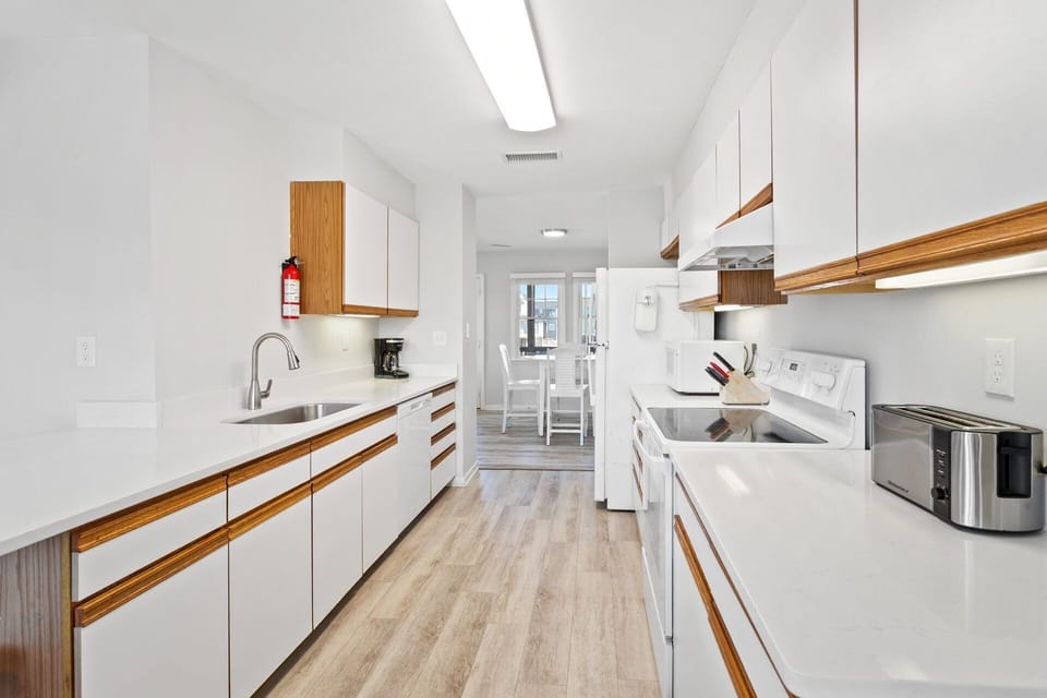 Prepare fresh meals or quick snacks in the updated kitchen featuring modern appliances and stone countertops.