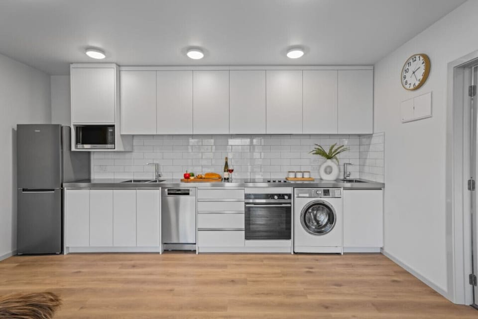 Fully equipped open-plan kitchen with quality appliances and a washer ideal for longer stays