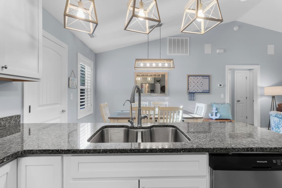 Chef‑ready kitchen featuring stainless steel appliances, granite countertops, a large island with extra seating, and every cooking essential