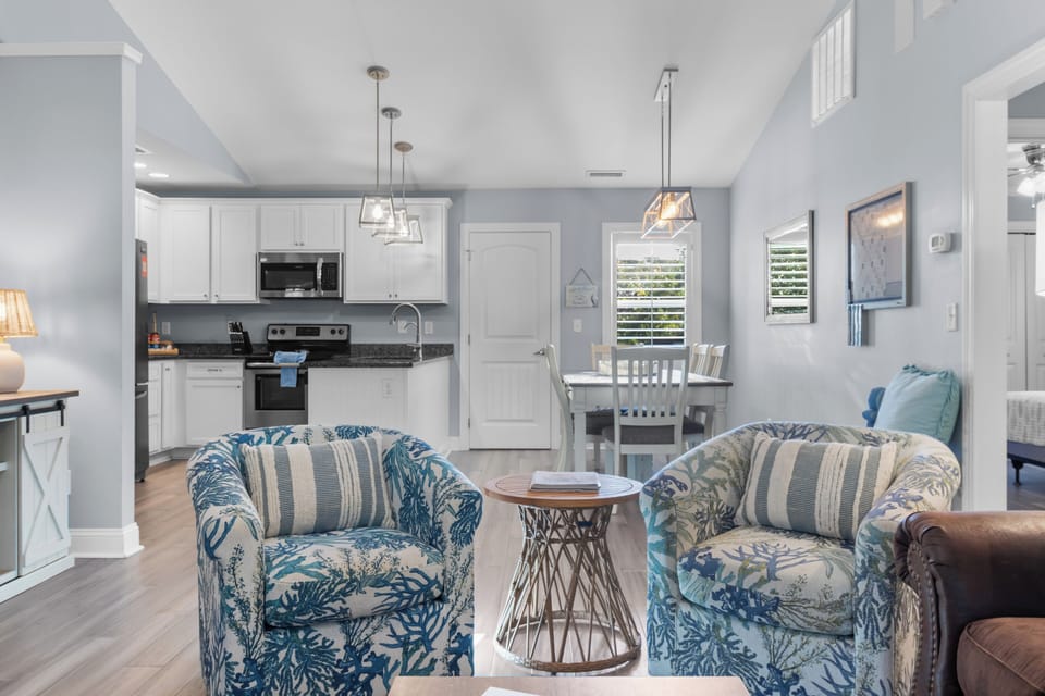 Spacious open‑concept living room with vaulted ceilings, a 65” Roku Smart TV, high‑speed Wi‑Fi, and cozy seating