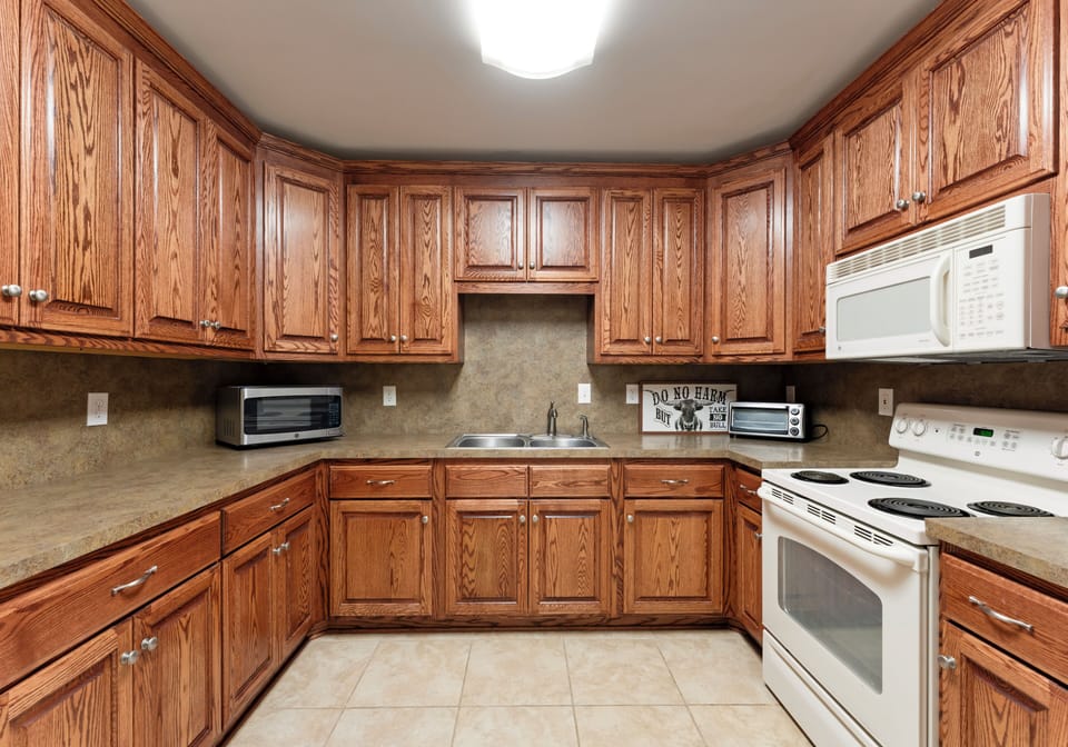 Kitchen with wooden cabinetry and white appliances.