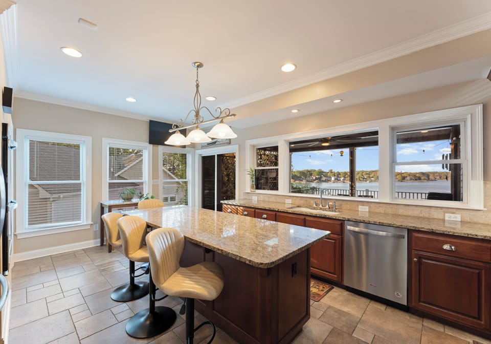 Kitchen with island, bar seating, and modern lighting.