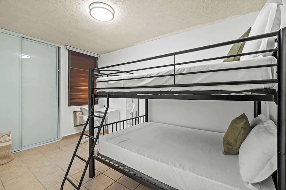 Efficient and stylish, this room offers a comfortable sleeping arrangement with its chic black bunk beds and spacious layout.