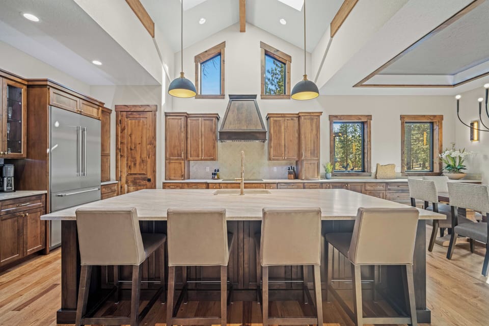 Your gourmet kitchen features soaring ceilings, warm wood cabinetry, and a stunning island perfect for memorable meals together.
