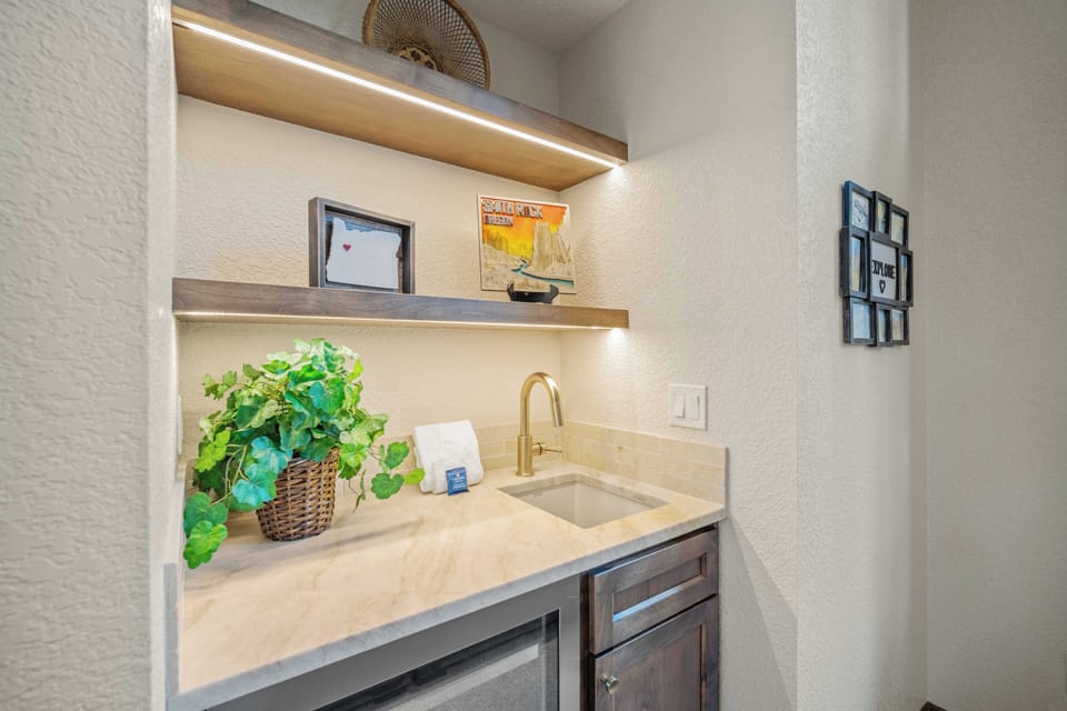 Your stylish kitchenette features warm wood cabinetry, elegant lighting, and thoughtful touches like fresh greenery to make meal prep a pleasure.