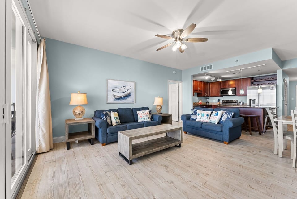 Spacious living area with coastal decor and an open kitchen layout.