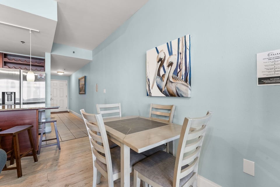 dining area with a modern table and chairs set against a light blue wall featuring pelican artwork